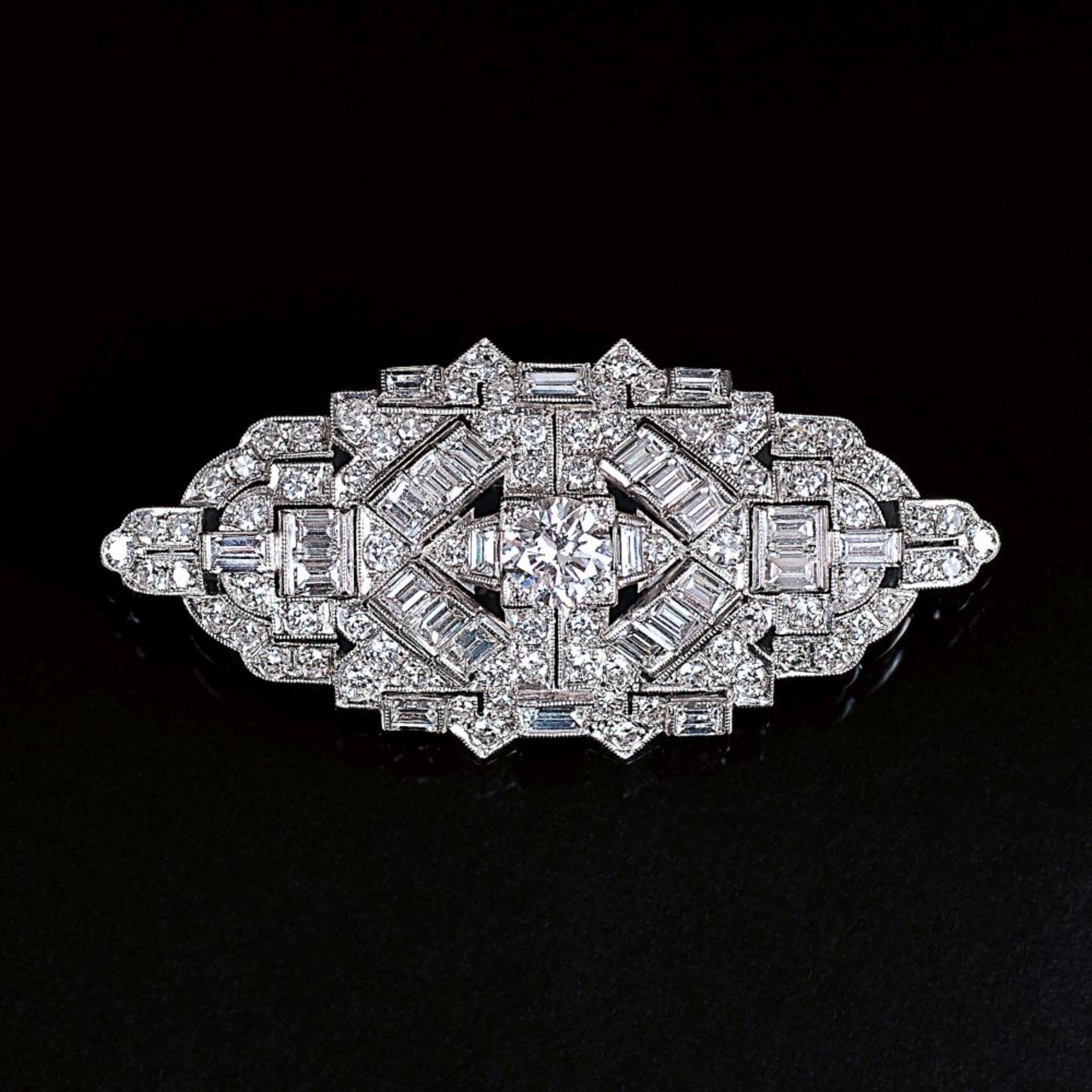 Art-déco Diamant-Brosche. Um 1920/25. 18 kt. WG. Reicher Besatz mit 105 weißen Diam. im Brillant-,