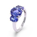 A TRILOGY OVAL CUT TANZANITE RING