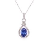 A VINTAGE STYLE HALO TANZANITE AND DIAMOND DROP PENDANT