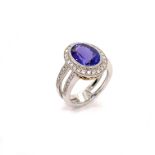 A DOUBLE SHANK HALO DESIGN TANZANITE AND DIAMOND RING