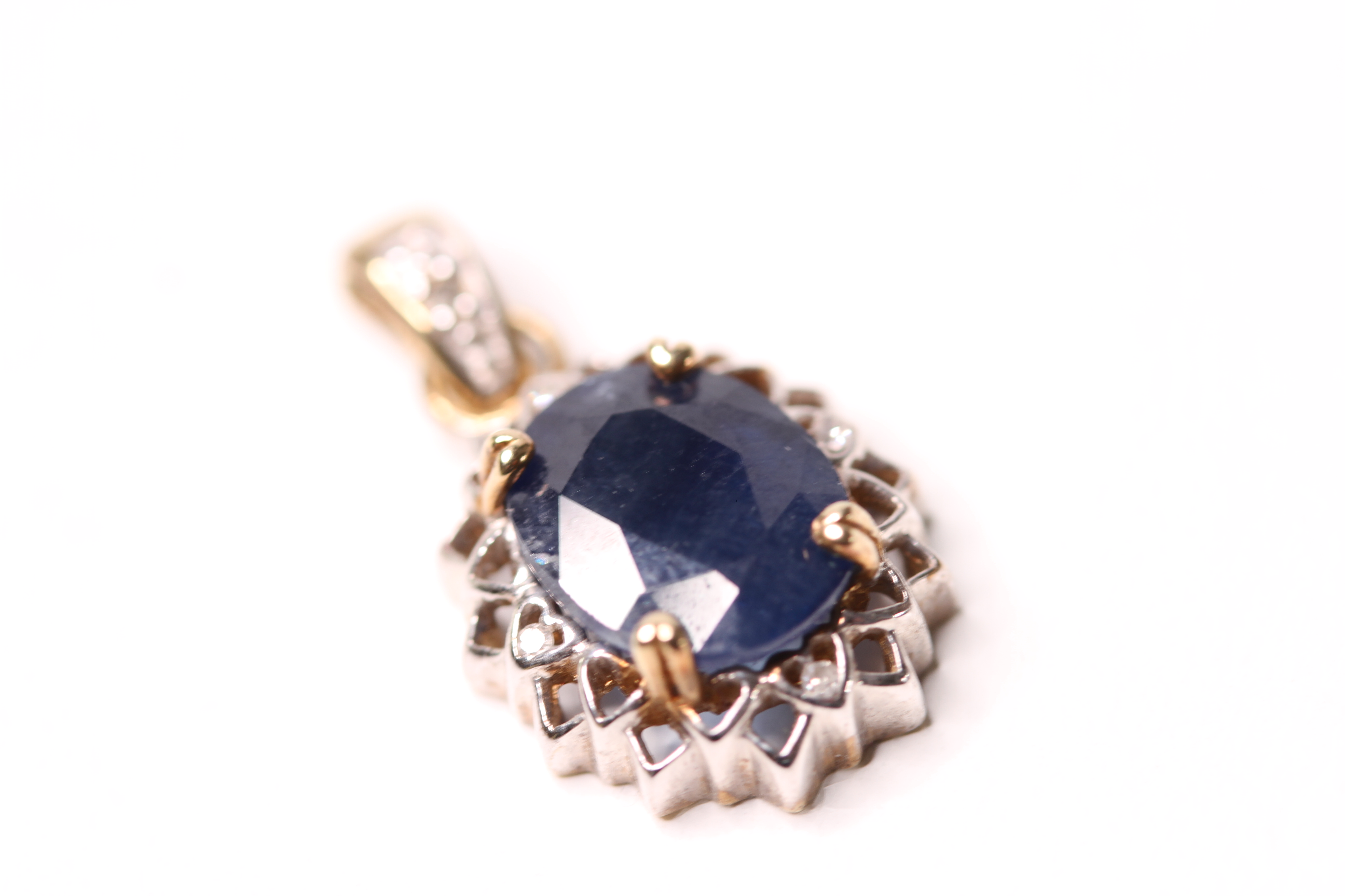 *TO BE SOLD WITHOUT RESERVE*A 9ct gold, sapphire and diamond pendant, claw set with the oval cut