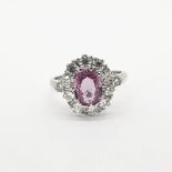 Pink Sapphire & Diamond Ring, oval pink sapphire set with claws inside a cluster surround of 10