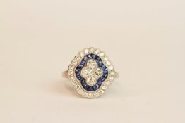 Platinum sapphire and diamond ring. Set with 4 central diamonds, surrounded by an inner halo of