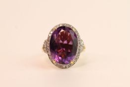 Amethyst & Diamond Cluster Ring, set with an oval cut amethyst, surrounded by round brilliant