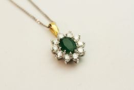 18ct white and yellow gold oval emerald and diamond cluster pendant on a silver chain, boxed.