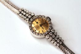 LADIES VINTAGE 14K TISSOT STYLIST WATCH, diamond set bezel and shoulders, round,champagne dial