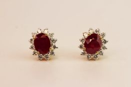 Pair of Ruby & Diamond Cluster Earrings, claw set with an oval cut ruby and round brilliant cut