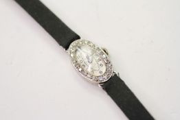 PLATINUM & DIAMOND COCKTAIL WRISTWATCH, oval silver dial with arabic numbers, 14mm case, diamond set