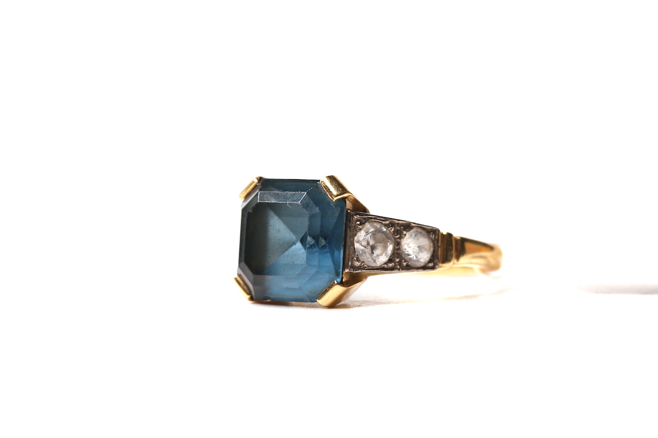 Blue Stone 18ct Ring, central square cut blue stone with white paste shoulders, hallmarked 18ct, 5.