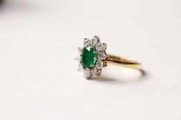 Emerald & Diamond Ring, set with an oval cut emerald, surrounded by 10 round brilliant cut diamonds,