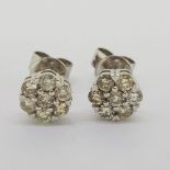 Pair of Diamond cluster studs, total approximate weight 0.72cts. Earrings and backs stamped 18ct
