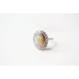 Opal & Diamond Cluster Ring, set with an oval cabochon cut opal, surrounded by round brilliant cut