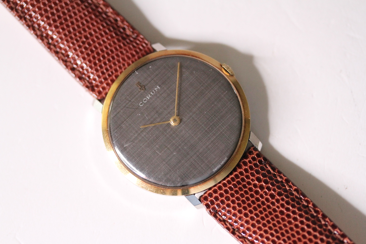 VINTAGE CORUM WRIST WATCH, circular grey dial, 34mm gold plated case, brown leather strap, snap case