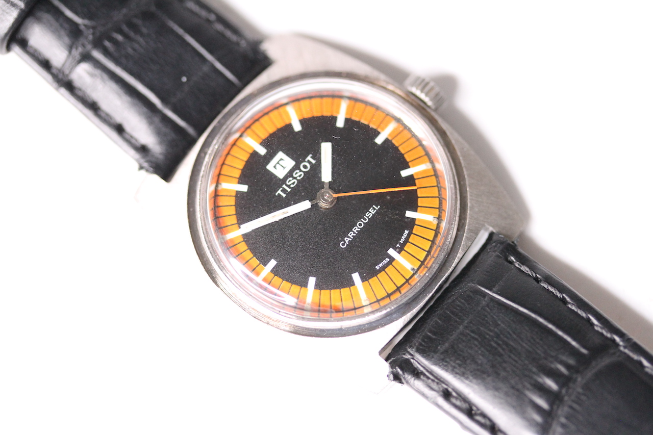 VINTAGE TISSOT CARROUSEL WRIST WATCH, circular black dial with orange outer minutes track, white