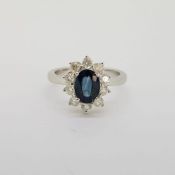 18 carat white gold oval sapphire and round brilliant cut diamond cluster ring. Approximate sapphire