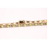 18ct yellow gold peridot and diamond line bracelet, boxed. Oval-cut peridots 8.00ct approx. R/C