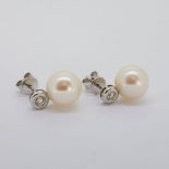 White gold bezel set diamond and freshwater pearl earrings. Butterflies stamped 750