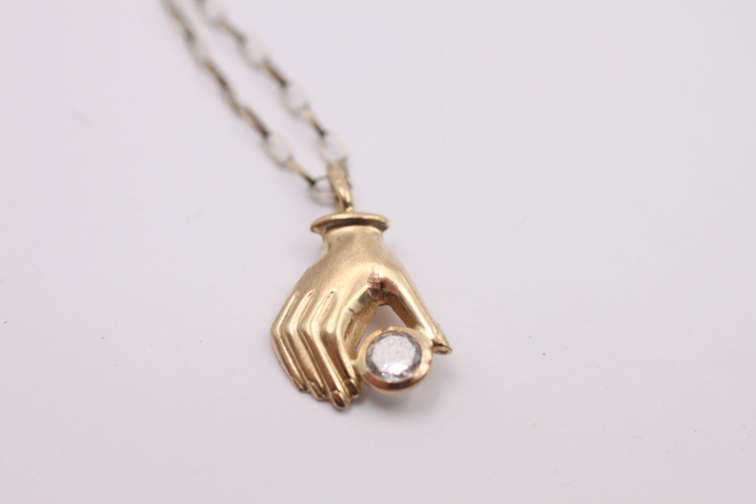 9ct gold hand holding a gemstone pendant necklace 1.2 grams gross - Image 3 of 4