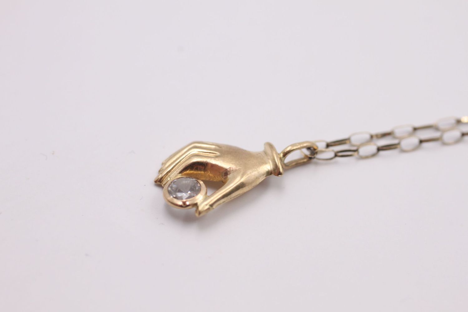 9ct gold hand holding a gemstone pendant necklace 1.2 grams gross - Image 2 of 4