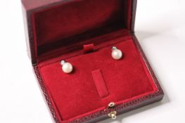 Pair of 9ct white gold white cultured pearl and rubover-set RBC diamond drop studs, boxed.