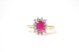 9ct yellow gold ring set with a step-cut ruby surrounded by a halo of diamonds. Ruby 1.51ct.