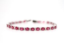 18ct white gold ruby and diamond line bracelet, boxed, Oval-cut rubies 13.14ct. Diamonds 0.48ct