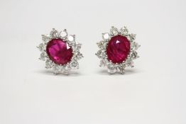 Pair of 18ct white gold large oval ruby and diamond cluster studs, boxed. Rubies 3.56ct. RBC