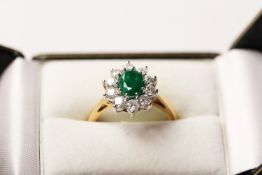 Emerald & Diamond Ring, set with an oval cut emerald, surrounded by 10 round brilliant cut diamonds,