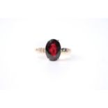 Garnet & Diamond Ring, set with an oval cut garnet, claw set, 18ct yellow gold, size M1/2, 3.4g.