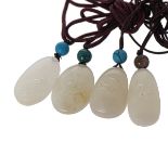 GROUP OF FOUR WHITE JADE PEBBLE PENDANTS