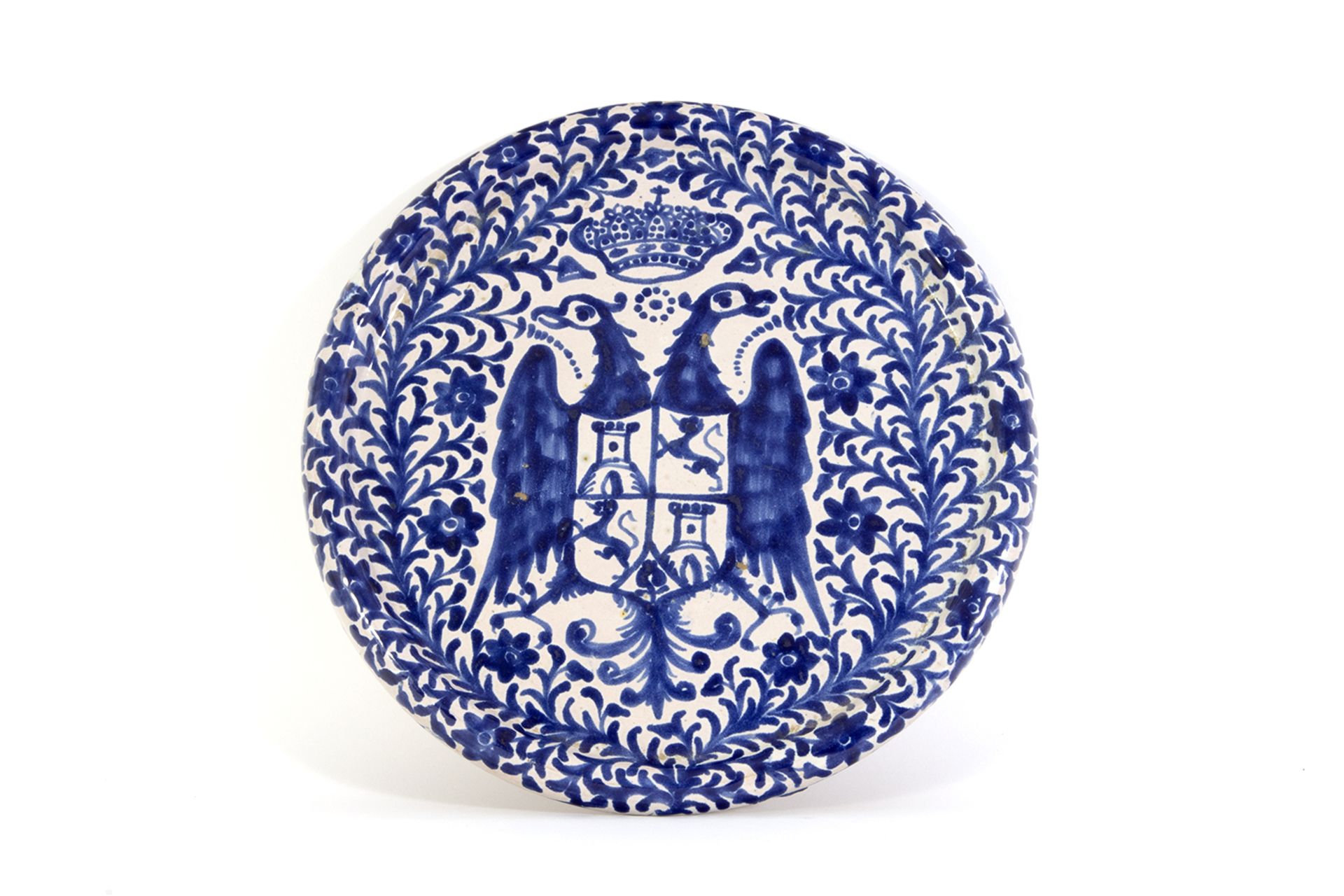 Plato en cerámica esmaltada azul y blanca de Fajalauza con representación de águila bicéfala coronad