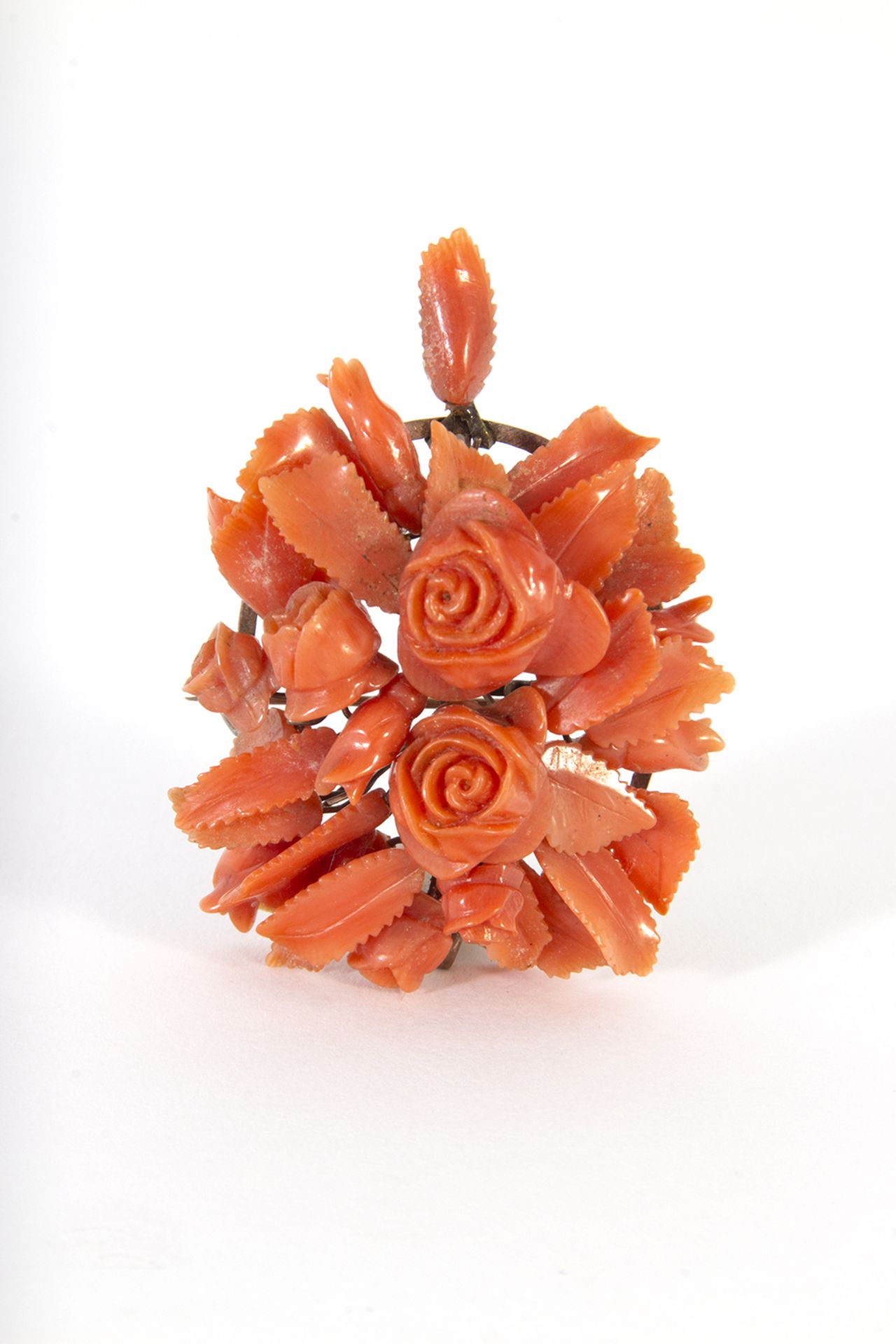 Broche-colgante en forma de flores en metal dorado y coral.