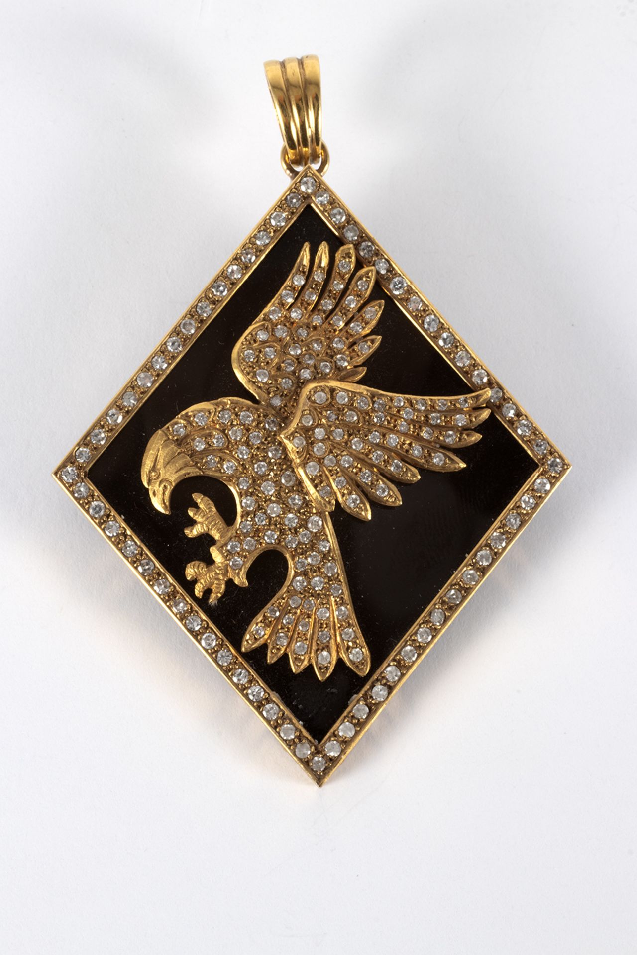 Pendant in gold and brilliant-cut diamonds in the shape of an eagle on an onyx plate.