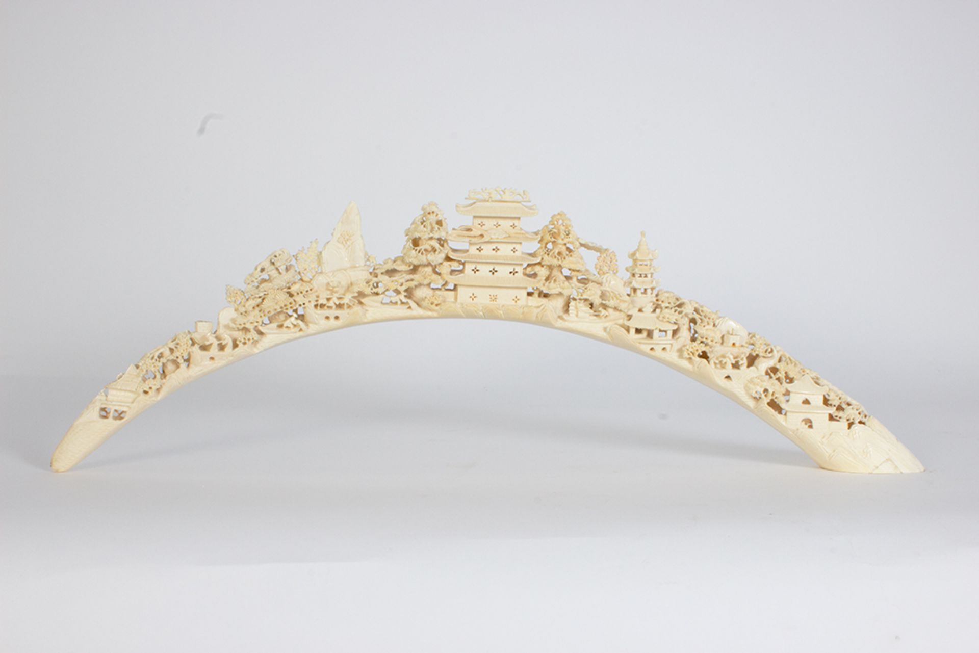 Ivory tusk carved with architectural motifs and figures.