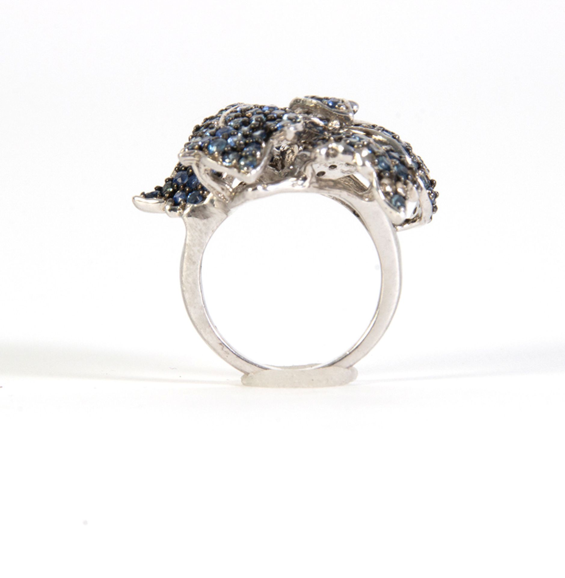 Silver ring with round cut blue sapphire leaves.