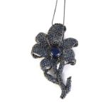 Silver flower pendant and blue sapphires, cabochon and round cut.