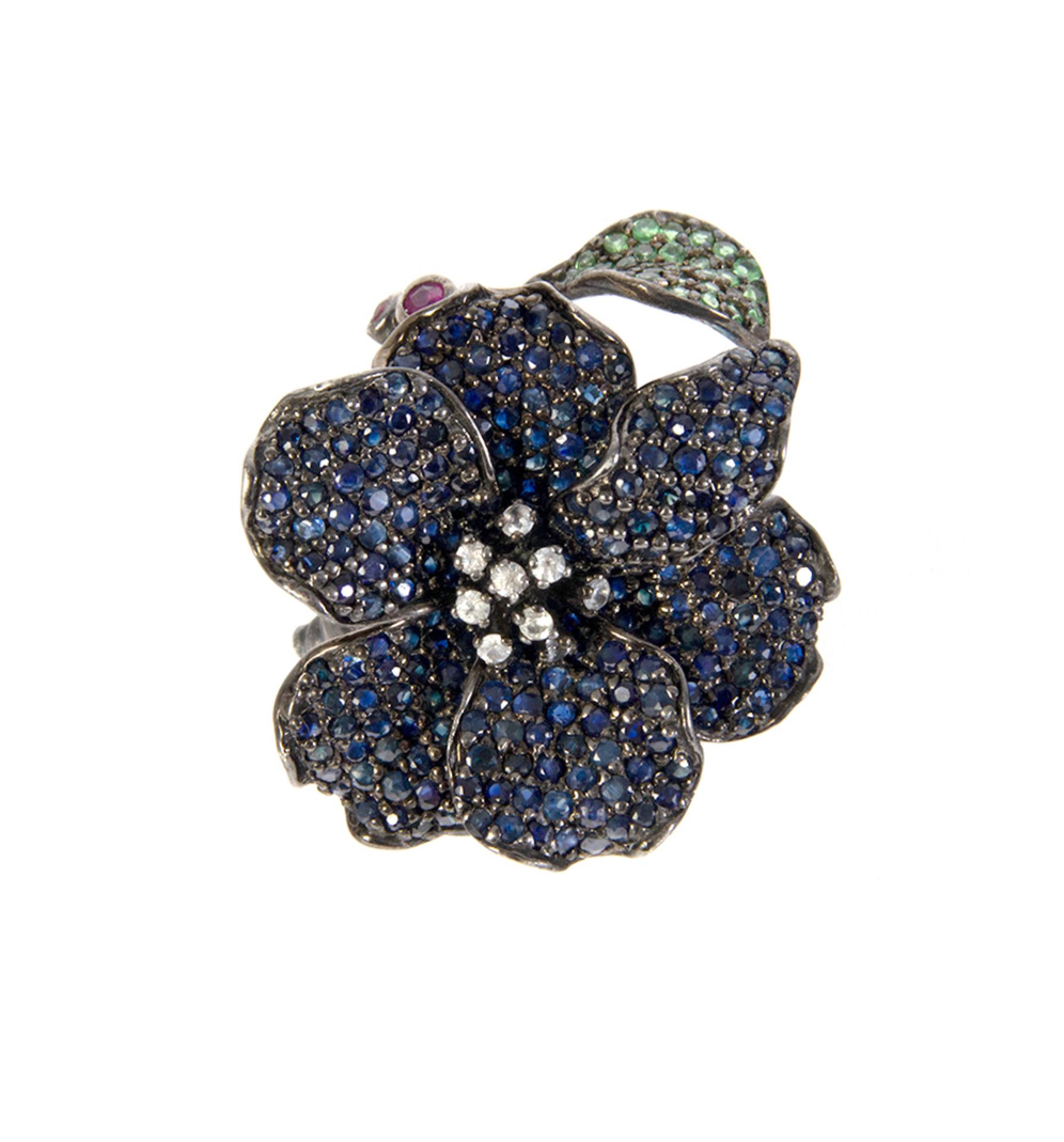 Flower ring in silver and blue sapphires, green garnets, rubies and zircons, round cut.