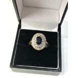 18ct gold diamond and sapphire ring weight 6.7g central stone measures approx 7mm by 5mm set with