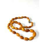 Antique egg yolk amber bead necklace largest bead measures approx 20mm by 13mm weight 26g