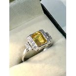 Fine platinum diamond and yellow sapphire ring set with large central yellow sapphire that