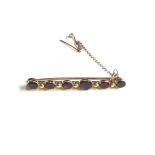 Gold table cut garnet bar brooch measures approx 5.1cm weight 4.9g