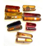 7 antique cased amber mounted cheroot holders