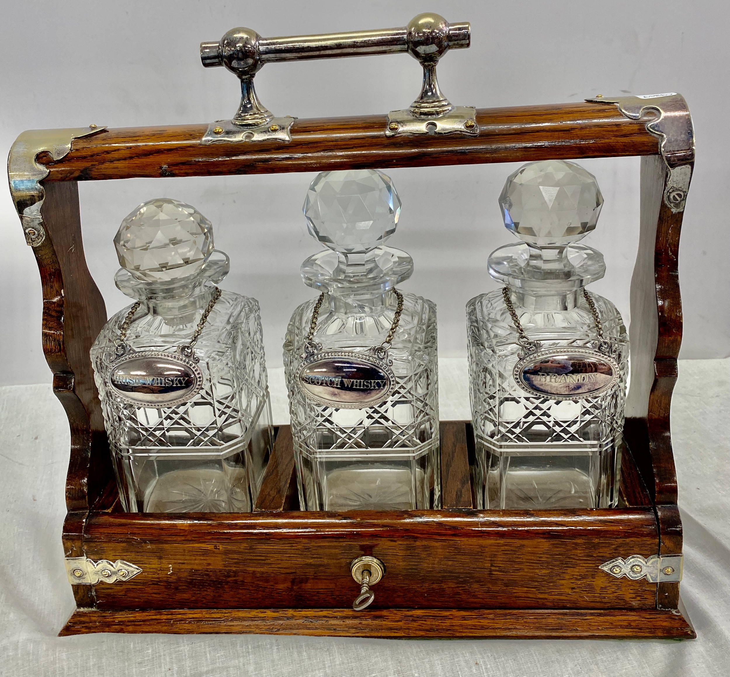 Vintage tantalus with silver plated drink labels, cut glass bottles, small damage to bottles
