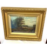 Antique gilt framed oil painting depicting a cottage in fields, frame measures approx 71cm by 56cm