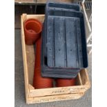 Wooden crate with plant pots and plastic trays