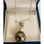 Tahitian 9ct white gold black pearl pendant with diamond bale on a 10ct white gold chain. D 0.