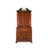 A George I walnut, crossbanded, featherbanded and parcel gilt bureau cabinet