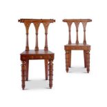 A pair of unusual George IV gothic carved oak hall chairs