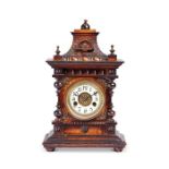 A late 19th century German stained beech carved mantel clock