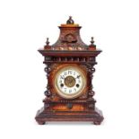 A late 19th century German stained beech carved mantel clock